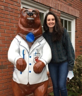 Doctor Panousis and statue of a bear holding toothbrush